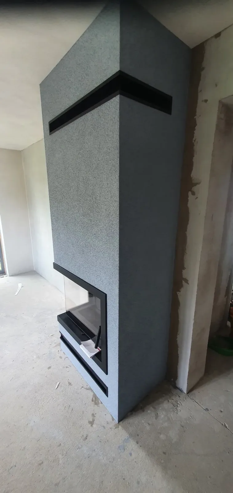 Černý minimalistický krb s prosklenou krbovou vložkou
